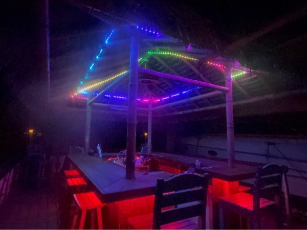 Colorfully lit outdoor bar with neon lights at night.